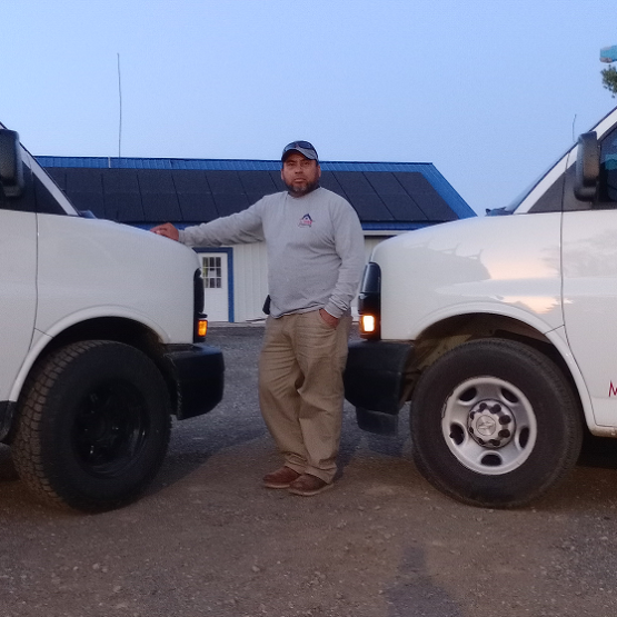 Diaz standing in the middle of two trucks